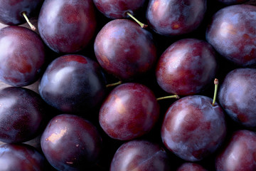 Ripe juicy plums as background.