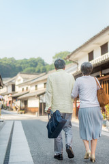 Obraz premium 旅行を楽しむシニア夫婦の後ろ姿