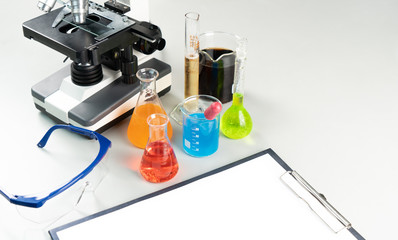 Science lecture clipboard with chemical experiment in school laboratory with beakers, microsope for...