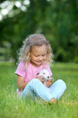 Girl with a cute little rabbit, outdoor, summer day