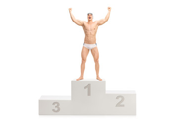 Young handsome swimmer posing on a winner's pedestal