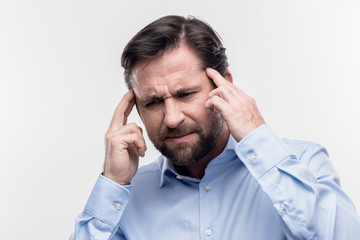 Strong headache. Image without face retouching with dark-haired businessman suffering from strong...
