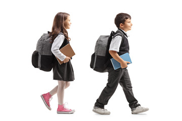 Schoolgirl and schoolboy with backpacks walking