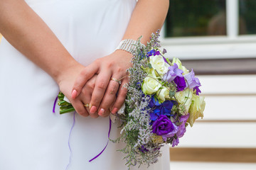 The bride holds the wedding bouquet in her hands