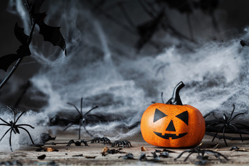 Halloween pumpkin and spooky decoration on dark wood.