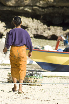 Woman going to corfs on beach in Indonesia