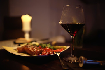 red wine glass serving / romantic dinner in the interior of the restaurant, a table served with a glass of grapes wine