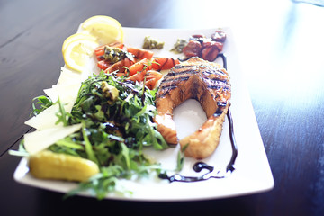 dinner at a restaurant grilled salmon / concept of a Mediterranean diet, seafood grilled and vegetables