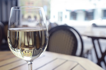 glass of white wine in the restaurant / white wine in the interior of the restaurant a table with glasses of wine, a romantic summer