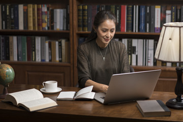 Elegant mature woman using laptop in study