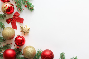 Christmas festive composition with fir branches, red and gold christmas decorations and copy space on white background, top view, flat lay.