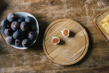 halves of fig on cutting board and pile in bowl on rustic wooden table