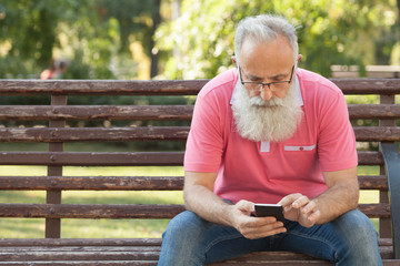 Fototapeta premium Senior man enjoying his smartphone outdoor