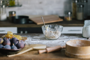 close-up shot of fig pie ingredients with dough standing on rustic wooden table