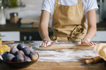 cropped shot of woman preparing dough for pie on rustic wooden table