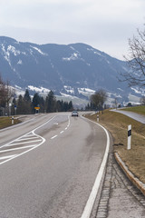 A picturesque asphalt road in the background of the mountains near the German city of Fuessen