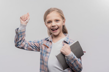 Beaming schoolgirl. Beaming blonde-haired schoolgirl feeling amazing after passing her exam on...