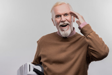 Smiling man. Retired smiling man wearing brown sweater feeling extremely excited on image without...