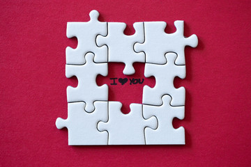 Fototapeta premium I love you under a missing piece of a puzzle on red background