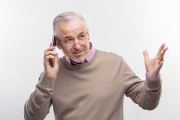 Emotional call. Image without face retouching with emotional grey-haired aged man calling his...