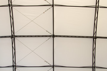 Geometrically symmetrical roof of the outer structure of the metal frame. The construction of the roof of the metal frame scene. Cables and frame. Installation and assembly of the pedestal.