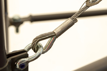 Obraz premium A looped connection of metal parts close-up on a white background. A quality photo of the connection of the rope with the metal bracket.