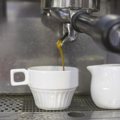 A coffee machine prepares two espresso in two glass cups in a cafe. The work of the coffee machine. Culture of coffee making in the city