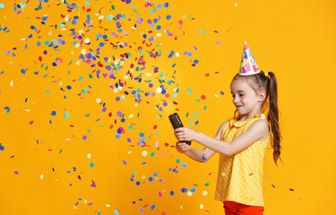 happy birthday child girl with confetti on yellow background - obrazy, fototapety, plakaty