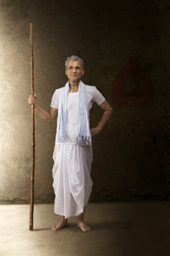 Portrait of senior farmer holding stick