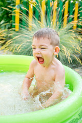 Children playing in inflatable baby pool. Kids swim and splash