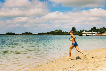 Fototapeta na wymiar Carefree boy running in water at the beach.