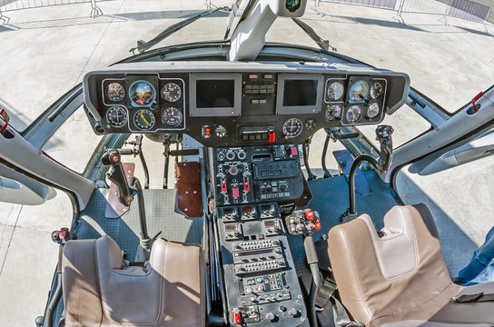 Wide view, a cockpit of a small helicopter, a control panel and a steering wheel.