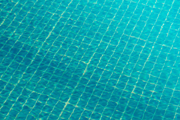 The bottom of the pool is made of blue square tiles in an interesting morning light. Empty pool - background for tourist sites.