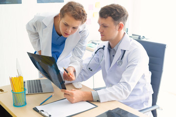 Obraz premium Doctor and nurse assistant are reading the x-ray film in the nursing room, feeling suspicious