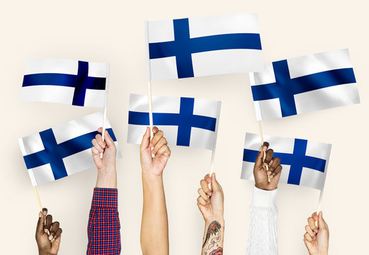 Hands waving flags of Finland