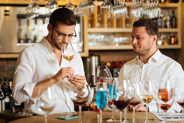 Restaurant sommeliers. Smart nice men standing together while tasting different kinds of wine