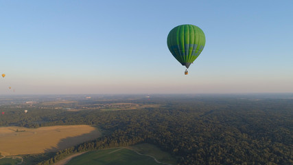 Aerial view Hot air balloon in sky over fields in countryside, beautiful sky and sunset. Aerostat fly over countryside.