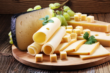Cheese platter with different cheese and grapes.