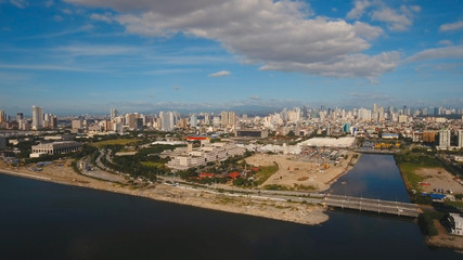 Fototapeta na wymiar Aerial view skyline of Manila city, Makati. Fly over city with skyscrapers and buildings. Aerial skyline of Manila. Modern city by sea, highway, cars, skyscrapers, shopping malls. Travel concept.
