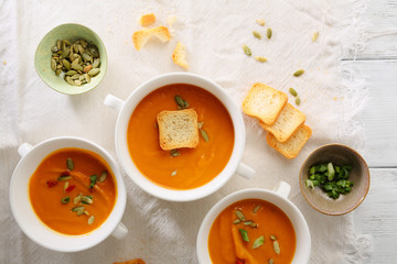 Three plates of pumpkin cream-soup