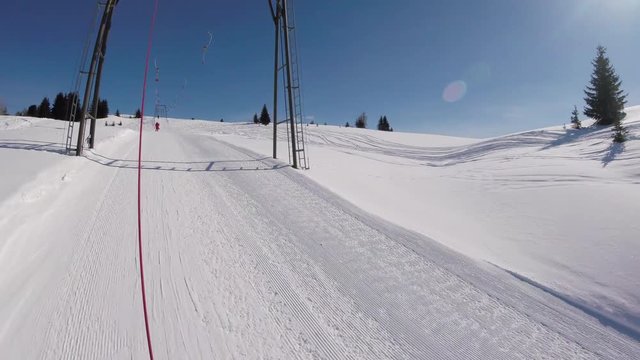 A skier going up on a ski lift, action camera footage