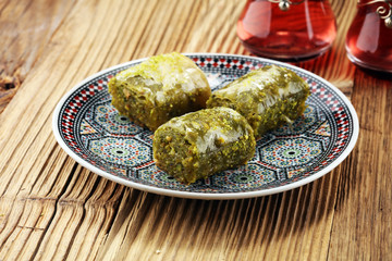 Turkish Dessert fıstık ezmesi baklava with pistachio on wooden table.