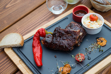 Delicious BBQ grilled pork ribs on cutting board served with Coleslaw salad and BBQ sauce