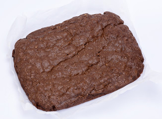 whole baked brownie pie on a white piece of parchment paper