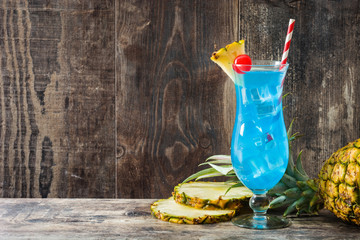 Blue Hawaiian cocktail on wooden table. Copyspace