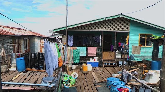A scenic steady shot of run down houses standing on the ocean.