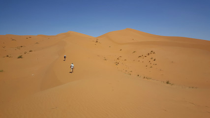 Fototapeta na wymiar Tourists walking in the dunes