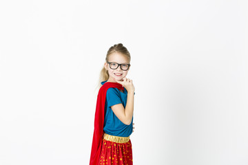 blond supergirl with glasses and red robe und blue shirt is posing in the studio