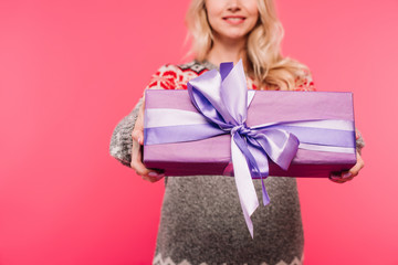 cropped image of girl in sweater showing violet present isolated on pink