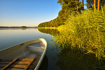 Calm Lake with fishing boat in morning light, northern Germany